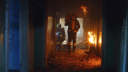 Fototapeta na wymiar Firemen running through fire and looking for survivors