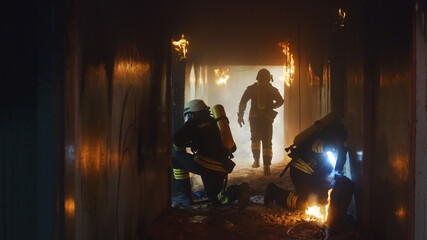 Firemen examining burning corridor during rescue operation