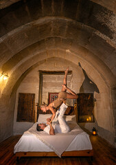 Couple man and woman in the old castle doing the acrobatic yoga stand with upside-down girl pose