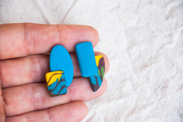 Fototapeta na wymiar Unique abstract mismatched earrings of polymer clay. Handmade jewelry.