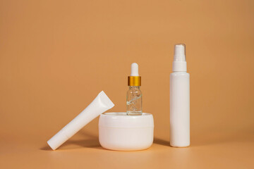 Copy space geometric shapes with night, day cream cosmetic oil, eye cream on yellow background. Unbranded bottles in mockup style. Beauty background with facial cosmetic products. Spa, beauty concept.