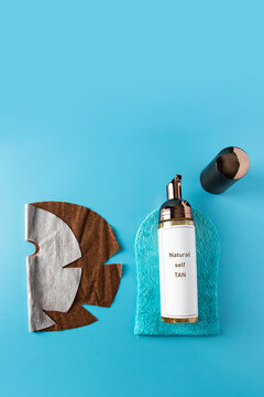 Self Tan Lotion And  Tanning Mitt On Blue Background With White Bronze Mask For Have Tan Without Sun Cocnept.Copy Space.