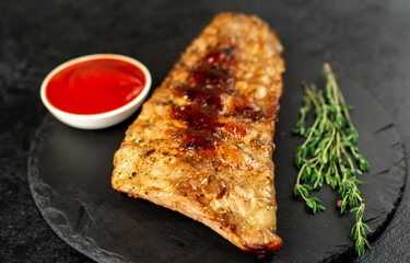 grilled pork ribs with spices on a stone background