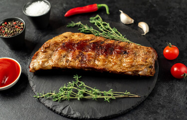 grilled pork ribs with spices on a stone background
