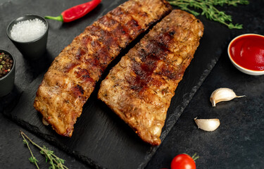 grilled pork ribs with spices on a stone background