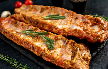 raw pork ribs marinated with spices on a stone background