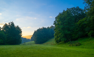 Sonnenaufgang über einer grünen Wiese Berglandschaft