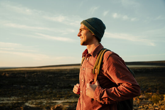 Caucasian male hiker walking through wilderness embracing nature walking with backpack