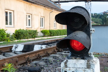 Piece of equipment shining a red light next to the train tracks