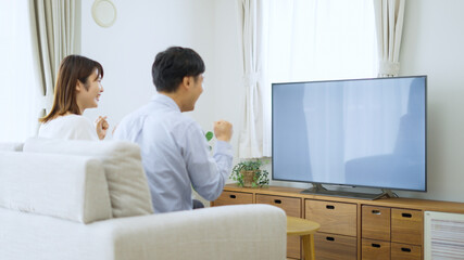 家でテレビを見る夫婦・カップル