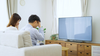家でテレビを見る夫婦・カップル