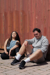 Young biracial couple with Down Syndrome in active wear sitting next to each other