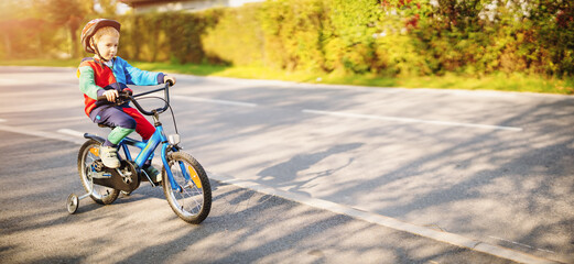 Happy boy on the bicycle on the road in the city.