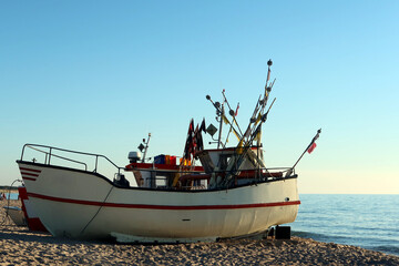 Fishing boat docking on the beach. Sunny summer evening on the beach