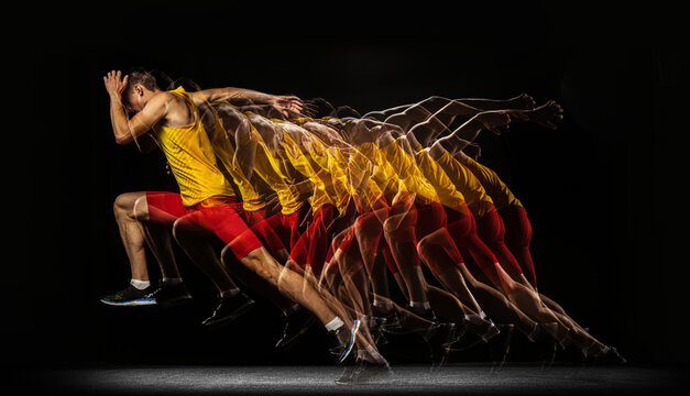 Portrait of young man, professional male athlete, runner in motion and action isolated on dark background. Stroboscope effect.