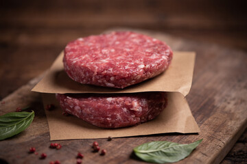 Raw ground beef meat burger steak cutlets on wooden background