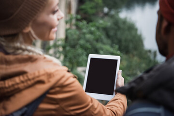 blurred and happy woman holding digital tablet with blank screen near boyfriend in woods