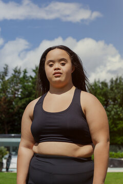 Portrait of young biracial woman with Down Syndrome in active wear looking confident