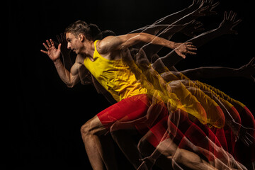 Portrait of young man, professional male athlete, runner in motion and action isolated on dark background. Stroboscope effect.