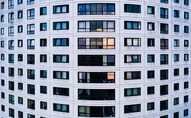 Aerial view of rows of windows in a city apartment block with curved facade