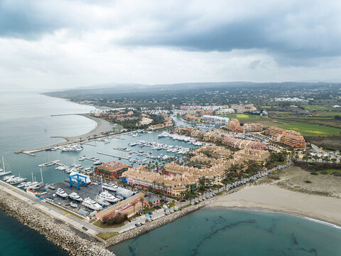 Unique aerial view of exclusive Sotogrande Bay - Costa del Sol. Cloudy day and rainy , beautiful sky colours. Luxury real estate and yacht. Famous location. 