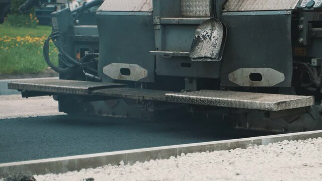 Close-up view of working road paving machine.