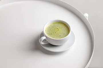 Green matcha tea with milk in cup on white table and white backgriund