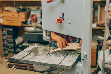 Carpenter man working at workshop studio while sawing wood