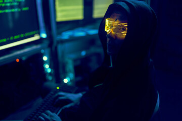 Cyber hacker breaks into databases to obtain information using a computer.