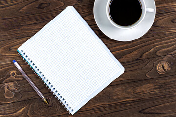 Notebook and cup of coffee on a wooden table. Background. Design. Business