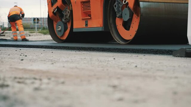 Road reconstruction. Heavy vibration road roller stacking hot asphalt.
