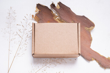 Brown flat cardboard carton box decorated with dried leaves, top view