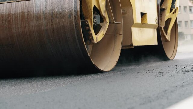 Road reconstruction. Heavy vibration road roller stacking hot asphalt.