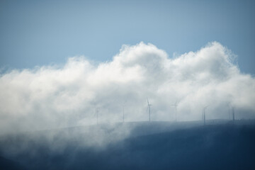 Niebla en la montaña junto a los aerogeneradores en los montes Gallegos. A Coruña, Galicia, España.