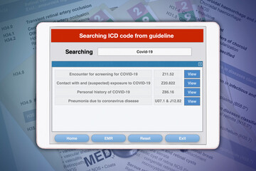 Searching diseases code of COVID-19 from ICD-10 code book by digital tablet.