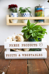 bunch of fresh basil and garlic in a decorative vegetable crate in the kitchen