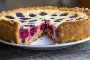 Blackberry pie on a wooden background in a cut