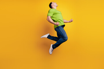 Fototapeta na wymiar Portrait of crazy astonsihed sporty guy jump rejoice on yellow wall