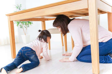 机の下に避難する親子