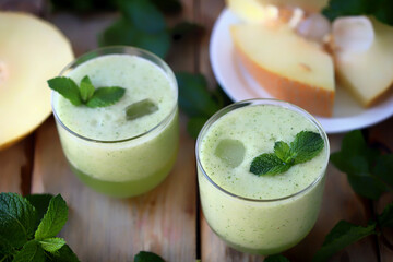 Smoothie melon mint in glasses on a wooden surface. Refreshing detox summer drink.