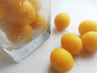 Cherry plum in drops of water in a transparent glass