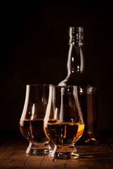 Scotch Whiskey in special glasses and bottle, old wooden background with negative space