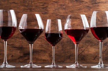 Selection of red wines on wine tasting. Dry, semi-dry, sweet red wine on old wooden table background