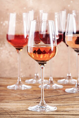 Rose wine glasses on the beige table. Rosado, rosato or blush wine tasting concept, negative space