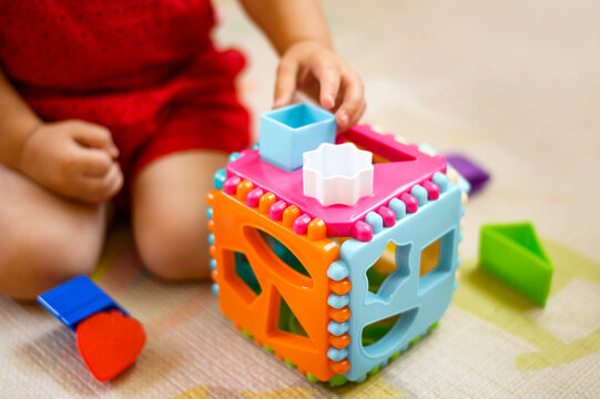 The child collects a multicolored sorter. Educational logic toy for kid's