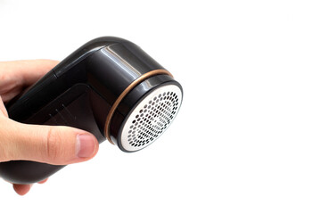 Hand holding a spool remover. Shaver for wool