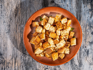 Toasted white bread croutons on a ceramic brown plate t