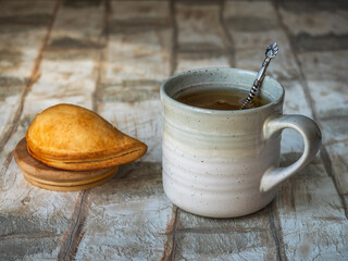 Light breakfast with tea in a large gray mug and a pie with cottage cheese
