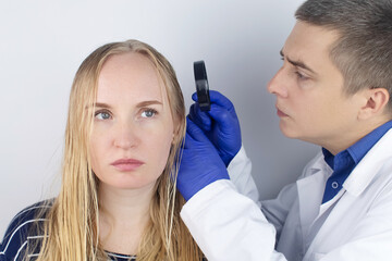 A trichologist examines a girl with oily hair. Problematic scalp and increased secretion of the...