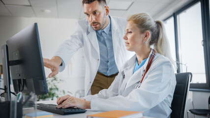 Hospital Medical Doctor's Office: Two Professional Physicians Talking, Consulting and Working on...